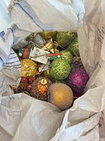 Close view of assorted glittered ball ornaments, bows and picks inside bag