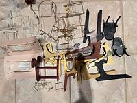 Group of wooden, metal and acrylic easels piled together on floor