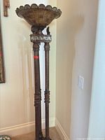 Full view of gilded neoclassical pedestal stand showing scalloped top and three fluted legs