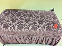 Top view of purple jacquard ottoman showing floral pattern and ruched skirt