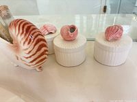 Side view of nautilus shell planter beside two trinket boxes showing shell lids