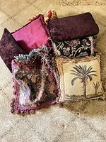 Group of six pillows showing various fabrics, colours, and trims