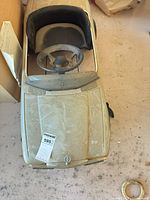 Top view of ride-on car showing steering wheel, interior, hood emblem, ticket and dust