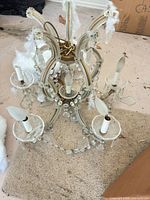 Full view of chandelier showing six arms, bulbs and crystal accents