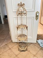 Full view of cream distressed 3-tier wrought iron plant stand