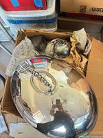 Top view of box showing large oval domed lid and assorted wrapped silver-plated items