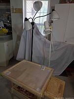 drafting table with multi-head floor lamp and clip lamp visible