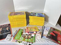 Overall lot: two stacks of National Geographic and assorted magazines spread out