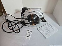 Craftsman circular saw with cord and manual on table