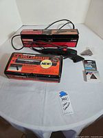 Overall lot view showing sander, screwdriver box, sanding sheets, loose pads
