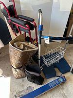 Group view showing folded red transport chair, silver walker, basket, cushion, boot, grab bar, tote