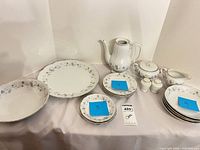 Full set arranged showing all pieces including plates, platter, bowl, teapot, sugar, creamer, shakers
