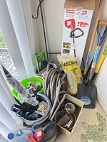 Overall lot showing string trimmer box, shovels, hose, buckets with hand tools, chemical jugs and stone bag