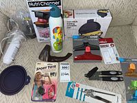 Overview of all boxed and loose kitchen gadgets and small appliances on sofa