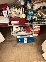 Entire lot on closet floor and shelf showing boxed stethoscope, Epsom salt, Sta-Flo cleaner, hand sanitizer, Cetaphil cleanser and additional toiletries