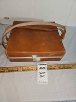Closed brown faux-leather case with strap