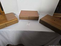 three wood-veneer cassette storage boxes displayed closed on table