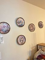 Five Lena Liu floral wall plates mounted on wall