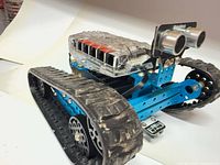 Left front view showing tracked chassis, controller enclosure, ultrasonic sensor