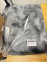 Folded shag carpet in clear plastic showing overall item