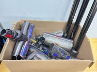 overview of box with multiple Dyson motorized heads and three wands visible