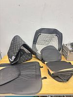 multiple quilted Porsche seat covers, cushions and mats on table