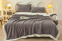 Web image showing blanket style on bed, grey diamond pattern with white sherpa reverse