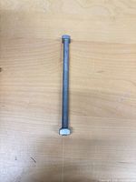 Single galvanized steel carriage bolt on tabletop