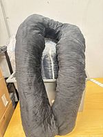 Black U-shaped body pillow displayed out of packaging