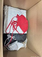 Box top view showing swimwear pieces atop white quilted item