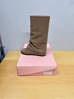 Side view of one tan boot on original pink shoebox