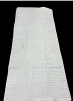 Full view of off-white rectangular runner rug showing tufted wave pattern