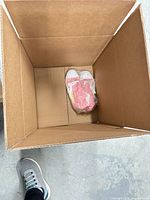 Empty box with single pink-white sneakers pair in plastic