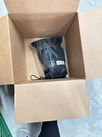 Box with single black drawstring bag inside