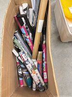 Top view of box showing multiple wrapped wallpaper rolls and poster tube