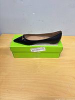 full view of black leather flat on original green box