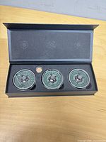 Presentation box open showing three mini roulette wheels seated in foam insert