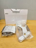Opened box with bidet attachment and hose in packaging