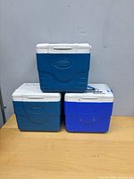 Three stacked Coleman coolers showing fronts
