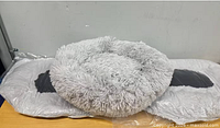 Three grey shaggy pet beds, one unwrapped on top of two wrapped units