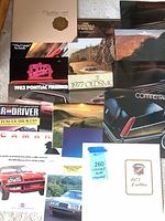Top-down overview showing all brochures spread out, variety of makes and formats
