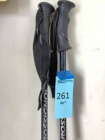 Full view of both Rossignol ski poles showing shafts, grips, and wrist straps