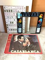 All items: laminated Casablanca poster, two Pac-Man arcade bezel pieces, playing card board