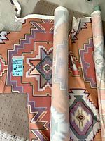 Rolled and folded Southwestern Aztec cotton canvas pieces showing full pattern and color palette, measurement tag visible