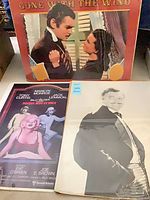 All three posters laid out together showing titles and protective sleeves