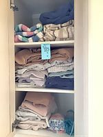 Cabinet shelves holding folded towels in assorted colours and patterns