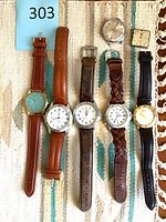 Group shot of six strapped watches plus two watch heads