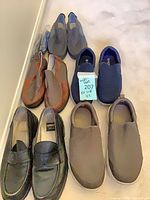 All five pairs of shoes arranged on floor showing styles and condition