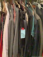 Closet rod with multiple men’s suit jackets and some ties visible