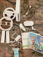 Entire lot with console, controllers, wheels, classic controller, power adapter, games visible